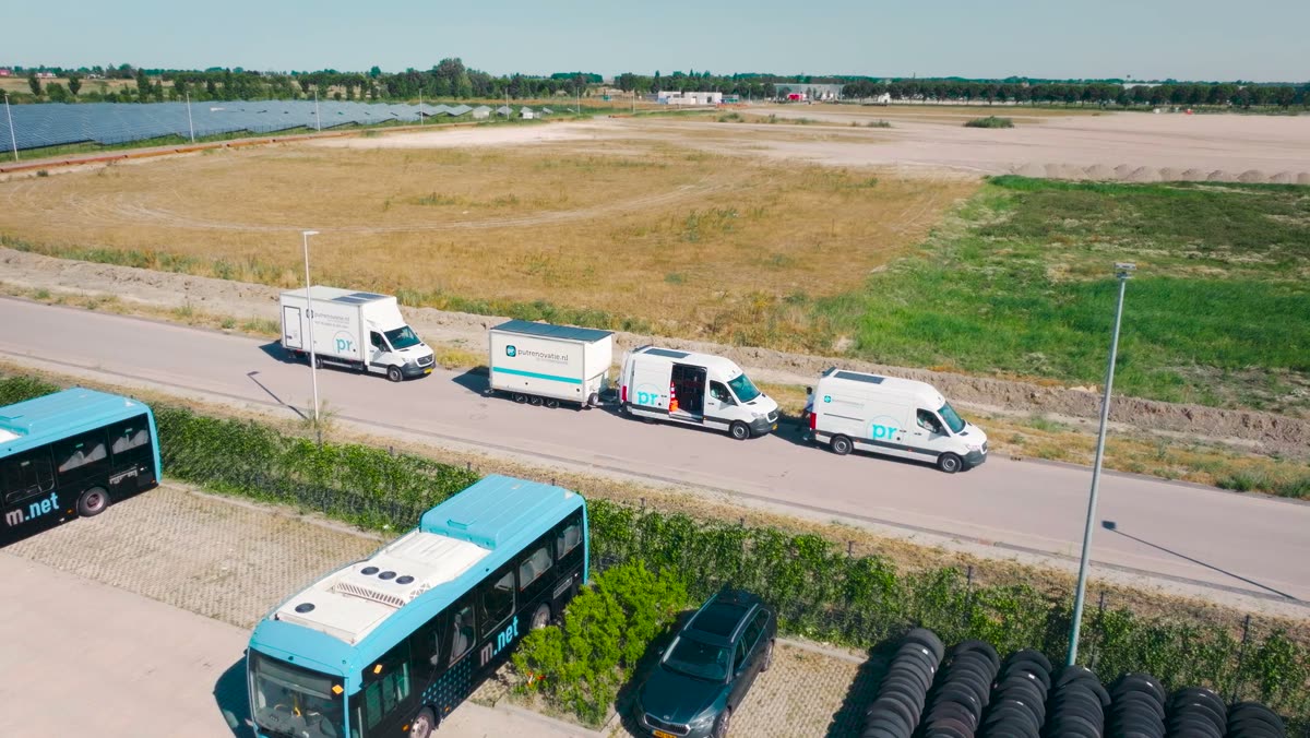 Dronebeeld van de bussen en wagens van Putrenovatie onderweg