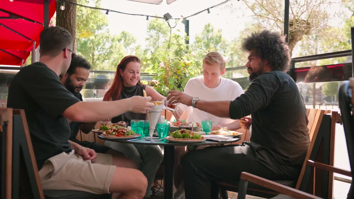 Collega's van Putrenovatie samen aan tafel op een terras