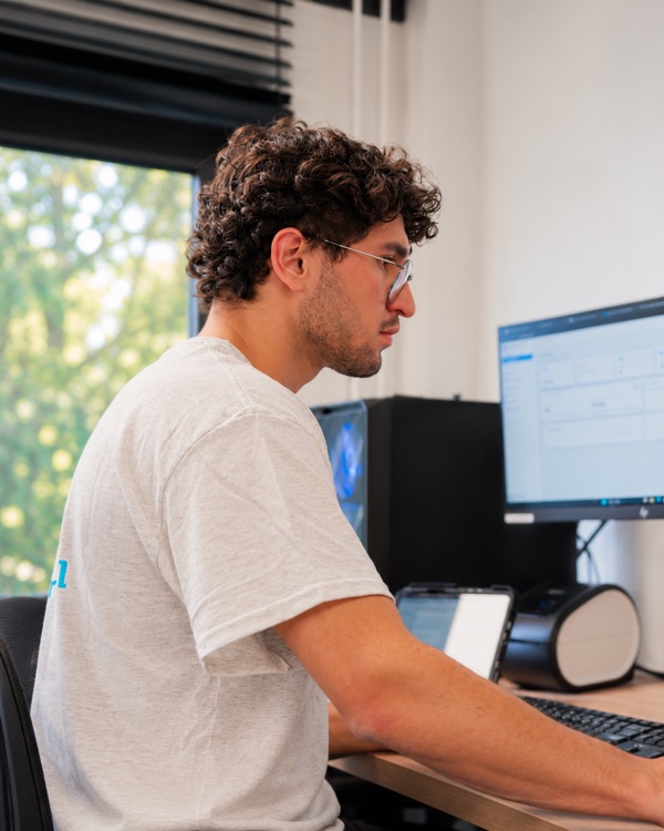 Collega van Putrenovatie aan het werk achter de computer op kantoor