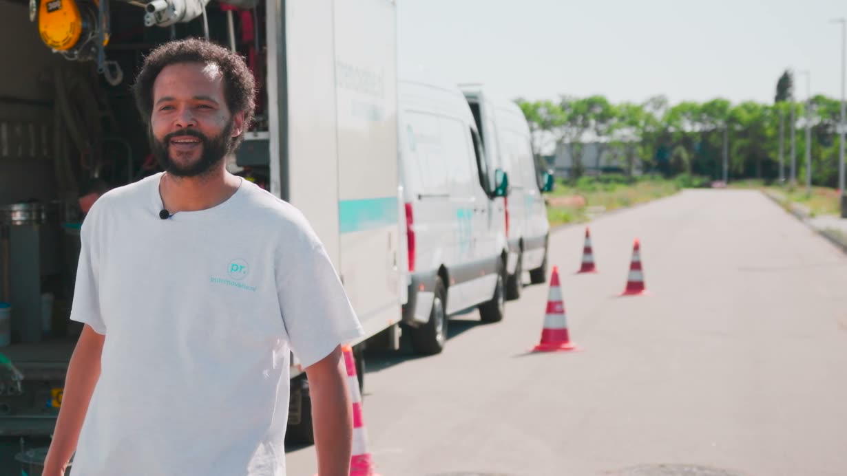 Collega van Putrenovatie op de werkplek, met de bussen en pionnen langs de weg